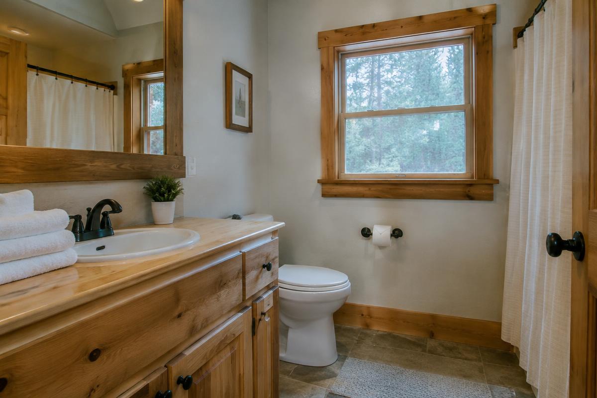 Clean cabin bathroom with wiped wood vanity and folded white towels staged